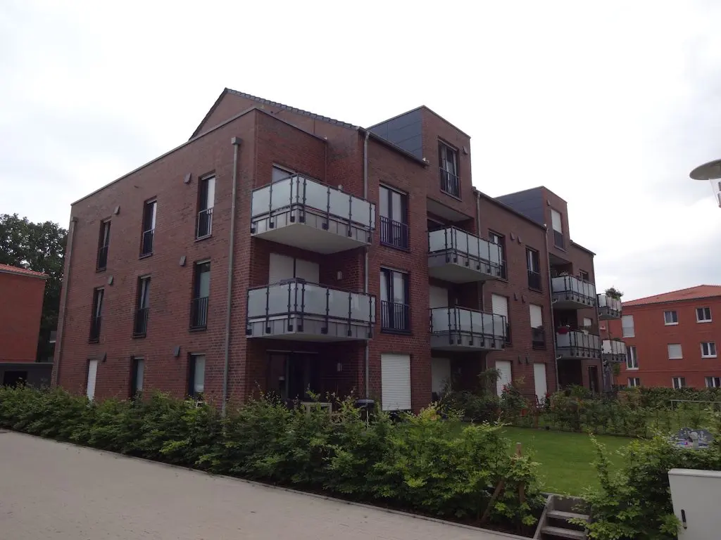 Ansicht eines modernen Mehrfamilienhauses (MFH) mit Ziegelmauerwerk und Balkonen