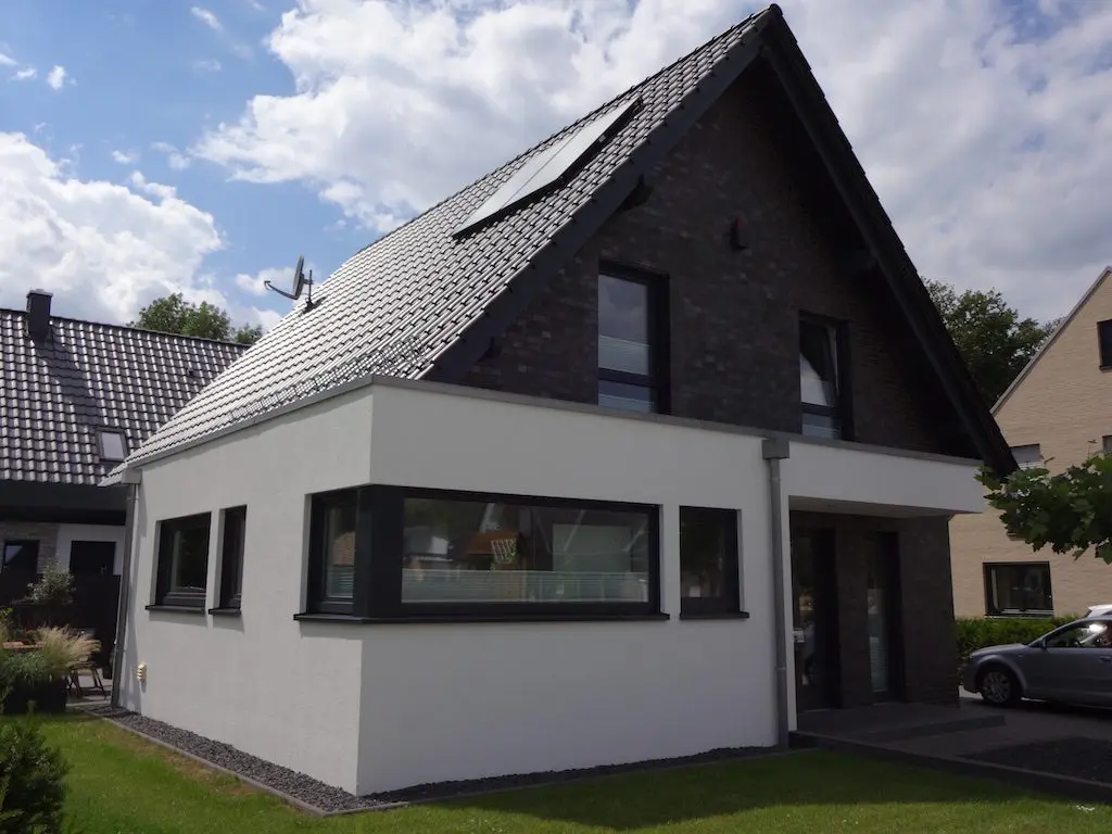 Helle Putzfassade kombiniert mit dunklem Backstein prägt dieses moderne Einfamilienhaus (EFH) 'Lotte'.