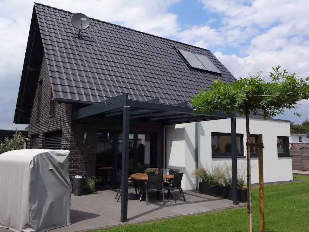 Fotografie eines Einfamilienhauses "Lotte" mit Terrasse, moderner Überdachung und gepflegtem Garten.