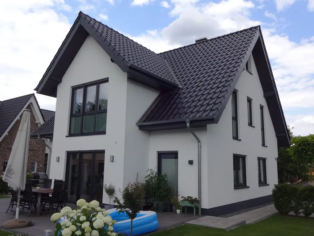BPE-EFH Otto: Modernes, zweistöckiges Einfamilienhaus mit dunklem Ziegeldach und hellen Fassade.