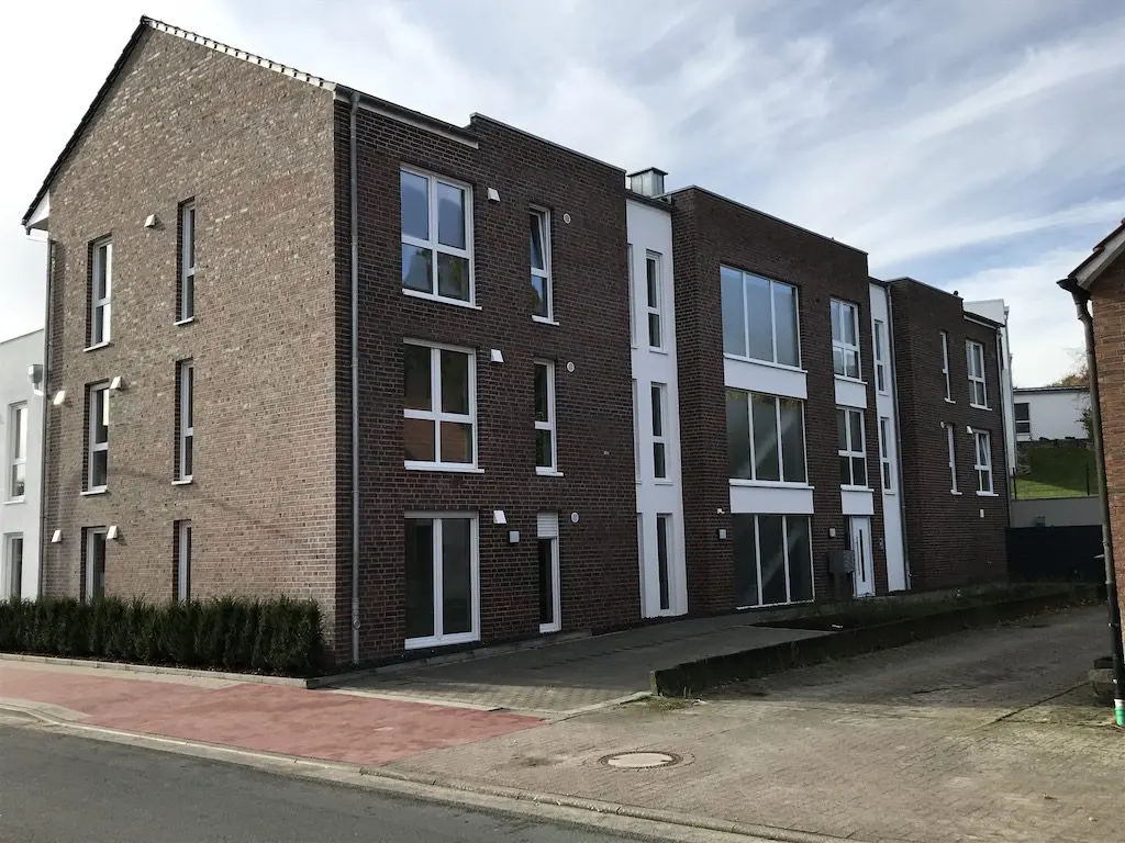 Ansicht eines modernen Mehrfamilienhauses mit roter Backsteinfassade und weißen Fensterrahmen, IMG_7521