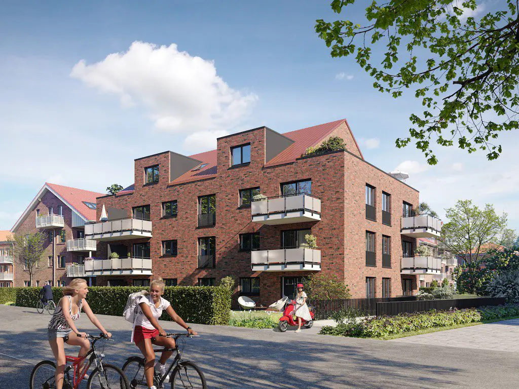 Mehrfamilienhaus mit rotem Dach, Backsteinfassade und Balkonen; Personen auf Fahrrädern und Roller im Vordergrund.