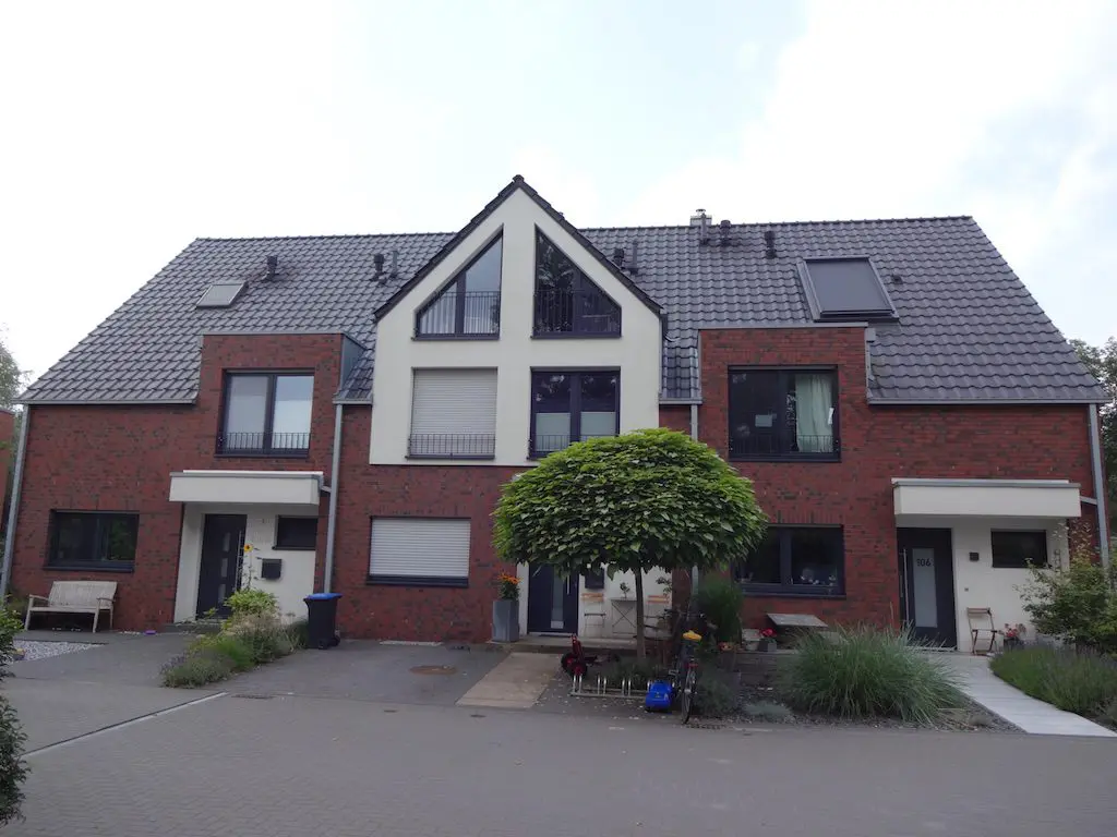 Ansicht von Reihenhäusern mit roter Backsteinfassade und grauen Ziegeldächern, Wasserweg 106-112.