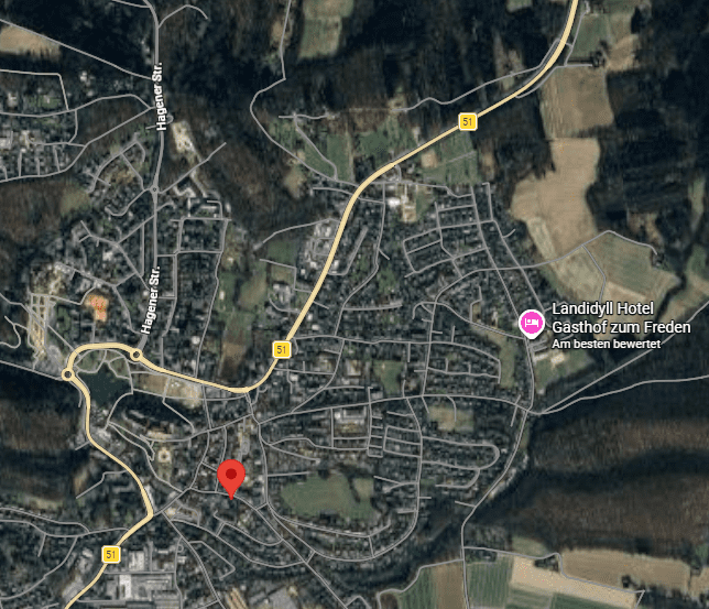 Drostenhof 6 Luftaufnahme von Drostenhof mit Straßen, Häusern, Wäldern und einem roten Marker auf einer Karte.